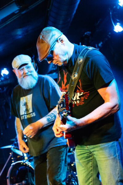 Ein Musiker einer Blues Band rackert sich bei einem Solo hart ab. Die Sänger pausiert und schaut begeistert zu. Aufgenommen von der besten Fotografin Bremens im Meisenfrei Blues Club Bremen.