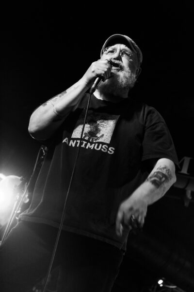 Eine Episches Foto auf dem Dirk Rademacher zu sehen ist. Der legendäre Sänger der Band Mad Dogs die im Meisenfrei ihren Auftritt hatten. Aus der Froschperspektive geschossen um ihn noch größer wirken zu lassen mit starkem Kontrast bearbeitet.