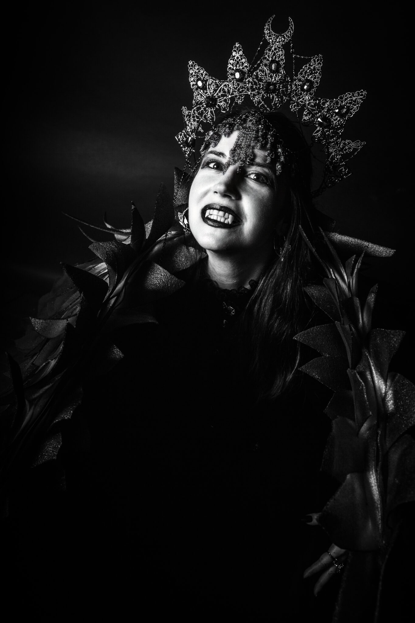 Dramatisches schwarzweiß Portrait einer Frau mit kunstvoller Krone und expressivem Gesichtsausdruck, mythologische Inszenierung in der künstlerischen Fotografie